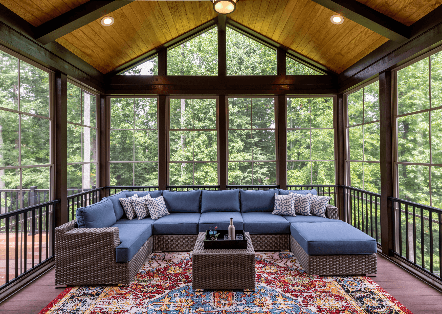 Screened room interior with wood ceiling and forest view